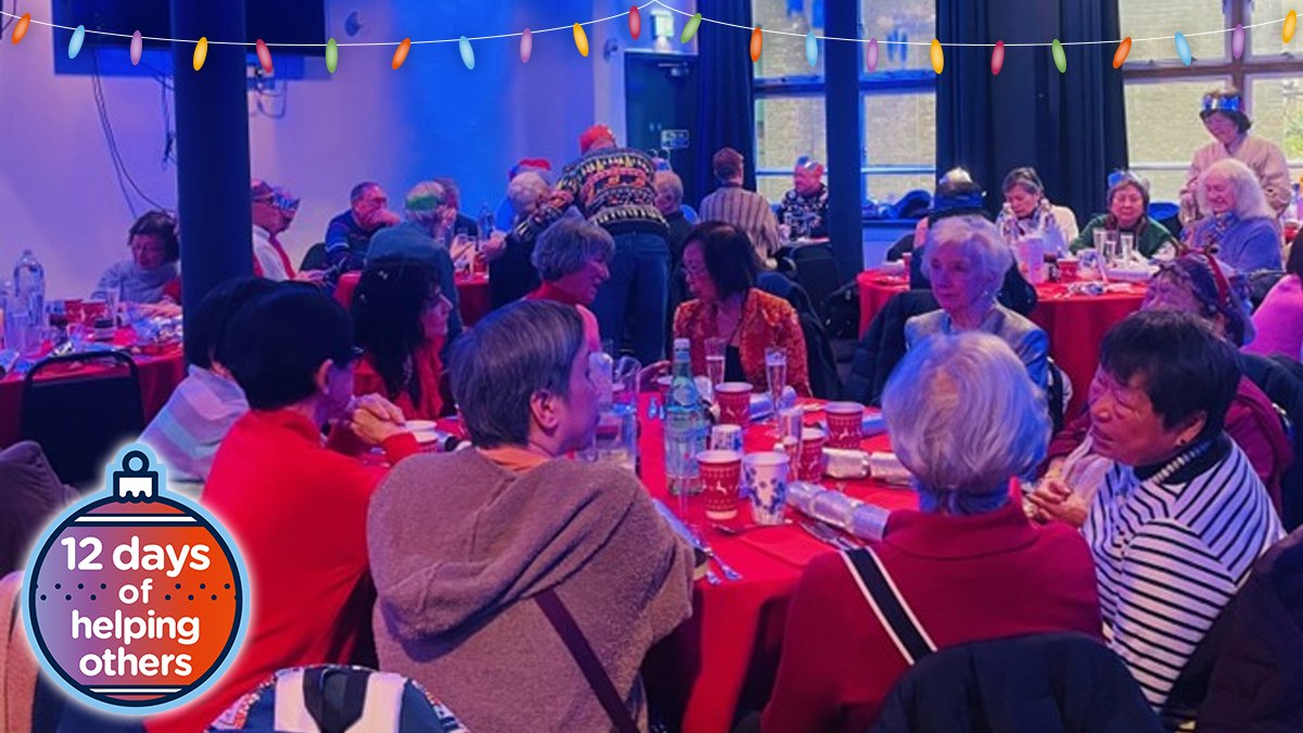 A group of people in Christmas outfits eating Christmas lunch