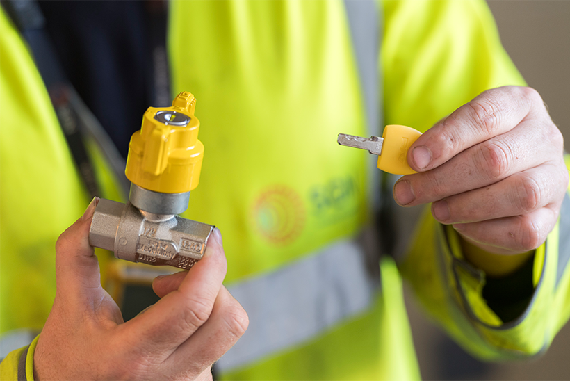 An engineer holding a locking cooker valve