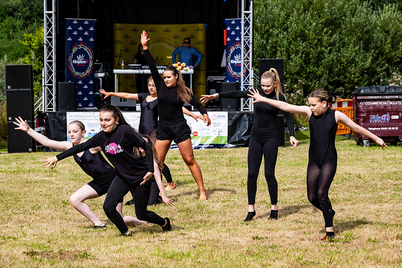 Six girls dancing in front of a stage