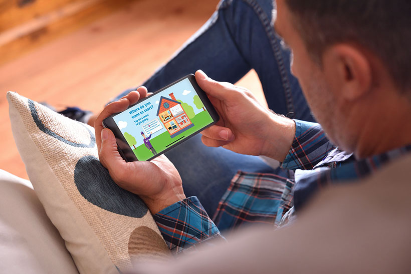 Man sitting on the sofa using an app on his phone