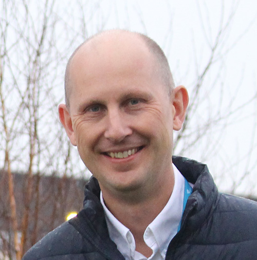 A headshot of a person smiling