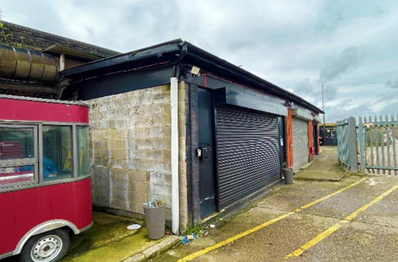 A small brick building with metal shutters down the front