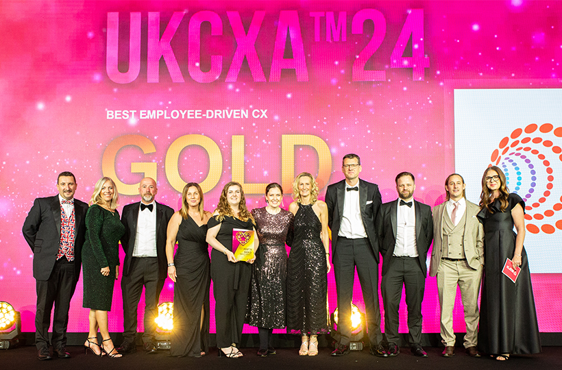 A group of people dressed smartly at an awards ceremony collecting an award