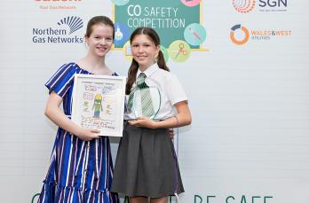 Winning artist Cody Motherwell with her award and her friend Sophie holding Cody’s poster.