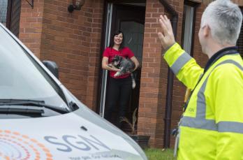 Gas engineer waving to customer