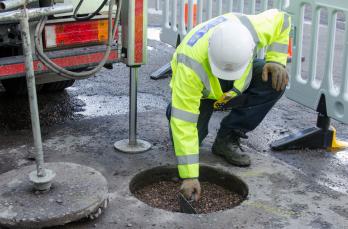 Gas engineer restoring road surface following core and vac