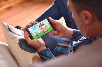 Man sitting on the sofa using an app on his phone