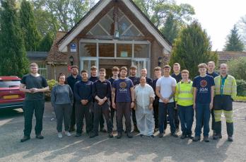 A group of people in SGN PPE and t-shirts outside a care home