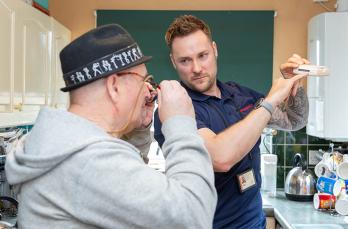 A Kent Fire and Rescue officer shows a client how their CO alarm works