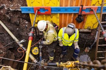 Two gas engineers working in an excavation 